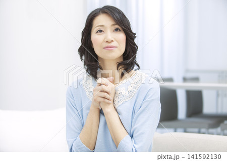 手を合わせて祈る中年女性 手を合わせて祈る中年女性 141592130