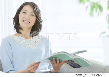 リビングで読書をする中年女性 141592208