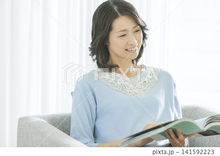 リビングで読書をする中年女性 リビングで読書をする中年女性 141592223