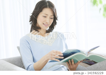 リビングで読書をする中年女性 リビングで読書をする中年女性 141592229