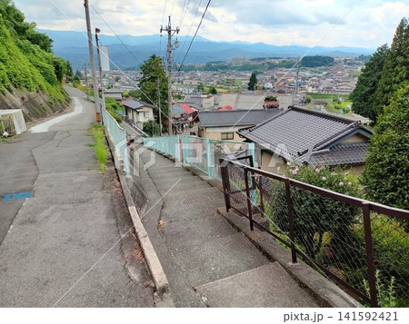 坂道の隣にある下りの階段と見下ろす町の風景 坂道の隣にある下りの階段と見下ろす町の風景 141592421