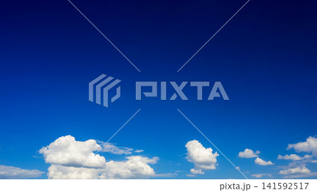 cumulus clouds at bottom of frame and big blue sky 141592517