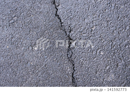 Asphalt texture with a deep crack, close-up top view, industrial background Asphalt texture with a deep crack, close-up top view, industrial background 141592773