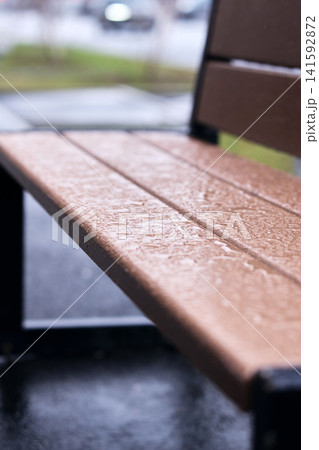 Rain beads on a lacquered wooden bench, illustrating durable outdoor furniture protection Rain beads on a lacquered wooden bench, illustrating durable outdoor furniture protection 141592872