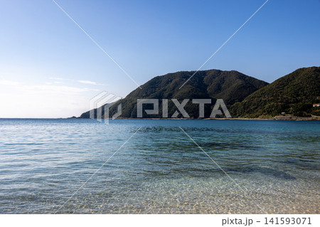底まで透き通る穏やかな海面と、奥に広がる濃い緑の山肌が美しい佐多岬の沿岸風景 底まで透き通る穏やかな海面と、奥に広がる濃い緑の山肌が美しい佐多岬の沿岸風景 141593071