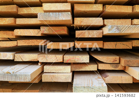 Stacked wooden planks texture. Freshly harvested wooden planks for construction 141593682
