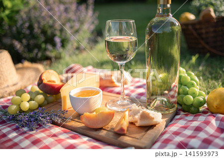 White wine cheese honey grapes peaches and lavender during summer picnic. 141593973