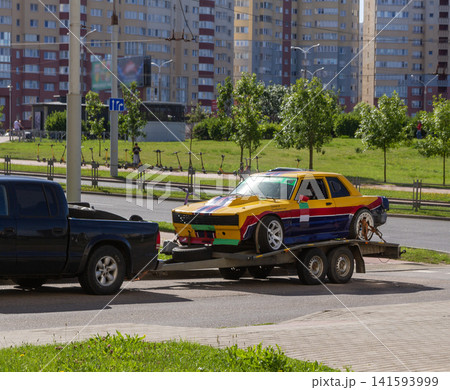 Black pickup truck towing a custom racing car on a trailer Black pickup truck towing a custom racing car on a trailer 141593999