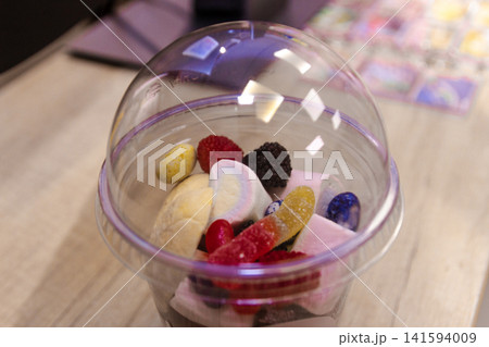 Sweet confectionery mix with sugar coated jelly worms in a plastic container Sweet confectionery mix with sugar coated jelly worms in a plastic container 141594009