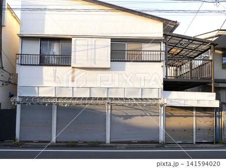 日除けの骨組みやシャッターが特徴的な日本の古い店舗兼住宅の全景 日除けの骨組みやシャッターが特徴的な日本の古い店舗兼住宅の全景 141594020