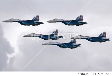 Russia Kubinka 12 April 2025. Russian Knights aerobatic team performing on Su-30SM and Su-35S fighter jets during an air show. Military aircraft in formation flight with smoke trails against blue sky Russia Kubinka 12 April 2025. Russian Knights aerobatic team performing on Su-30SM and Su-35S fighter jets during an air show. Military aircraft in formation flight with smoke trails against blue sky 141594068