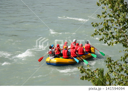 Russia Gorny Altai Katun River 22 June 2025. Group of 10 people rafting in one boat on rapid river. Adventure tourism and extreme water sport in mountain landscape Russia Gorny Altai Katun River 22 June 2025. Group of 10 people rafting in one boat on rapid river. Adventure tourism and extreme water sport in mountain landscape 141594094