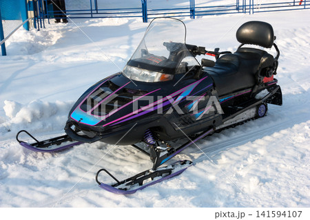 Russia Primorsky Krai Arsenyev 20 January 2026. Snowmobile parked on snow close up view. Winter motor vehicle for snow travel and recreation in Far East mountain landscape 141594107
