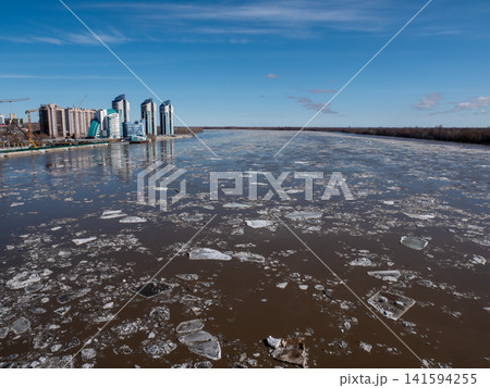 April 09 2026 Barnaul Russia aerial view of Ob River ice drift floating ice with new high-rise buildings near River Station spring cityscape urban development. April 09 2026 Barnaul Russia aerial view of Ob River ice drift floating ice with new high-rise buildings near River Station spring cityscape urban development. 141594255