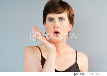 A Young Woman with a Surprised Expression is Showcasing Shock or Disbelief in a Captivating Way A Young Woman with a Surprised Expression is Showcasing Shock or Disbelief in a Captivating Way 141594309