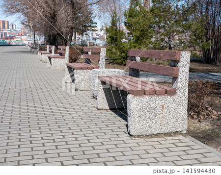 Park benches in urban park outdoor seating recreation public space green area. Park benches in urban park outdoor seating recreation public space green area. 141594430