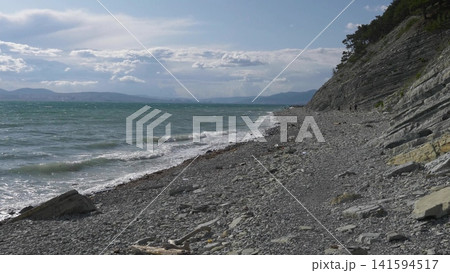 Panoramic view of the sea from a rocky hillside with pine trees under a clear blue summer sky Panoramic view of the sea from a rocky hillside with pine trees under a clear blue summer sky 141594517