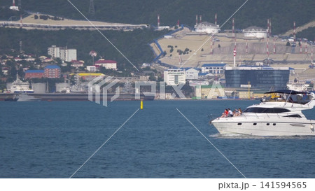 August 12, 2025: White motorboat near the port of Novorossiysk, Russia, with people relaxing on board August 12, 2025: White motorboat near the port of Novorossiysk, Russia, with people relaxing on board 141594565