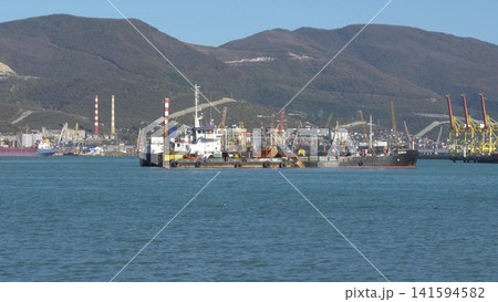 August 22 2025 View of Novorossiysk port Russia with cargo ships and cranes on the coastline. Industrial maritime scene on the Black Sea 141594582