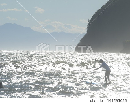 湘南でSUPを楽しむ人物と輝く海 湘南でSUPを楽しむ人物と輝く海 141595036