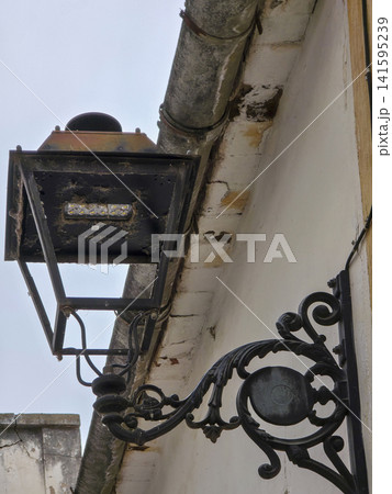 Old wrought iron street lantern with modern LED module on building wall in town Old wrought iron street lantern with modern LED module on building wall in town 141595239