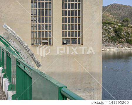Water level measurement gauge shows water levels at a dam reservoir in a mountainous area during daylight hours Water level measurement gauge shows water levels at a dam reservoir in a mountainous area during daylight hours 141595260
