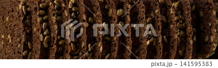 close up of wholemeal rye bread with sunflower seeds , food textured. Background of wholemeal rye bread. rye bread close up. 141595383