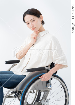車椅子に乗る考える女性 車椅子に乗る考える女性 141596956