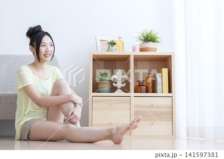 リビングでフットマッサージをする女性 リビングでフットマッサージをする女性 141597381