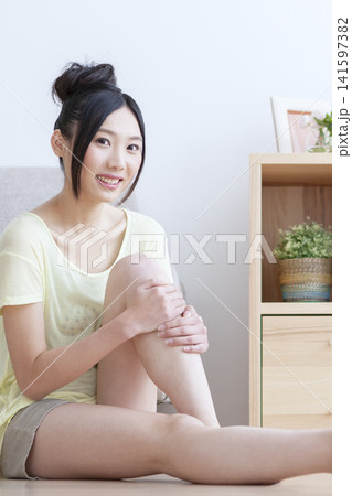 リビングでフットマッサージをする女性 リビングでフットマッサージをする女性 141597382