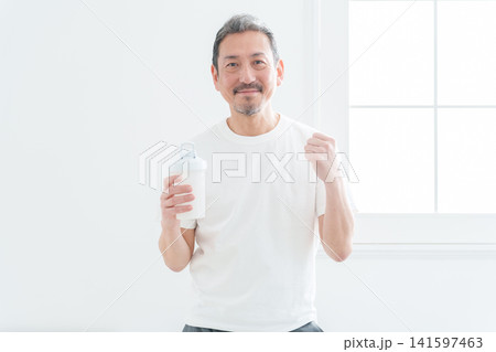 プロテインを持ってガッツポーズをする中高年男性 プロテインを持ってガッツポーズをする中高年男性 141597463