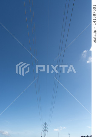 快晴の空で前後に伸びる送電線と送電鉄塔 快晴の空で前後に伸びる送電線と送電鉄塔 141597601