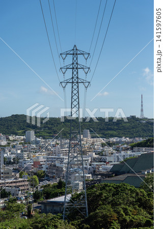 快晴の空で前後に伸びる送電線と街中の送電鉄塔 快晴の空で前後に伸びる送電線と街中の送電鉄塔 141597605