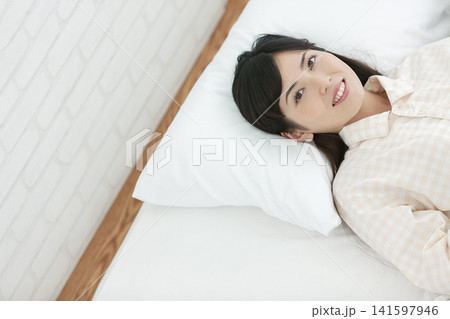 ベッドで寝るパジャマ姿の女性 ベッドで寝るパジャマ姿の女性 141597946