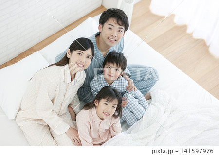 ベッドに座るパジャマ姿の家族 141597976