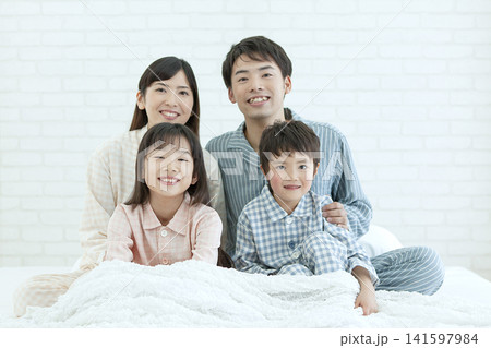 ベッドに座るパジャマ姿の家族 ベッドに座るパジャマ姿の家族 141597984