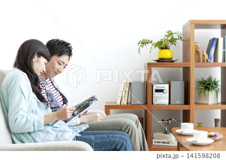 ソファで本を見る夫婦 141598208