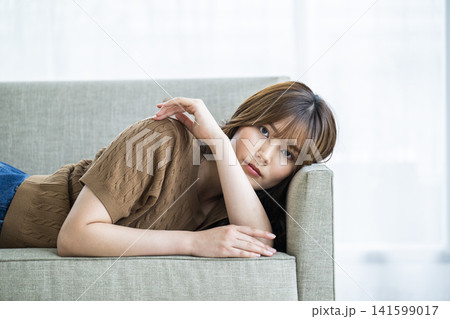 ソファーに横になる若い女性 ソファーに横になる若い女性 141599017