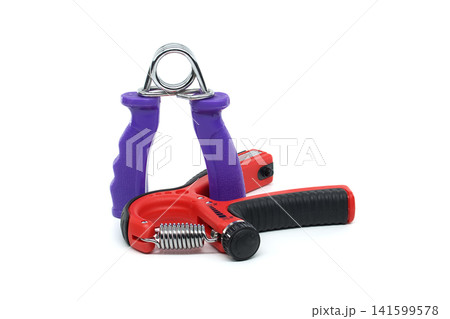 Two hand grip strengtheners with metal springs and colorful handles on white background 141599578