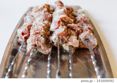 Raw marinated lamb skewers prepared for barbecue grilling. Raw marinated lamb skewers prepared for barbecue grilling. 141600092