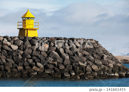 Yellow lighthouse tower stands on a stone breakwater. Reykjavik Yellow lighthouse tower stands on a stone breakwater. Reykjavik 141601455