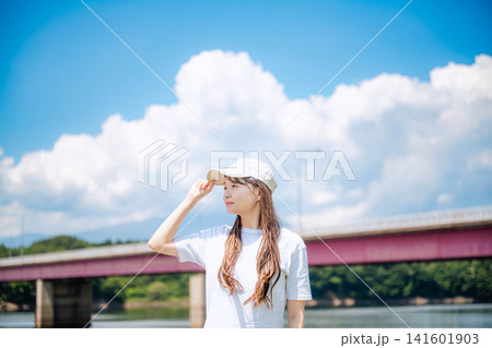 夏空の下で遠くを見つめる白キャップの女性 夏空の下で遠くを見つめる白キャップの女性 141601903