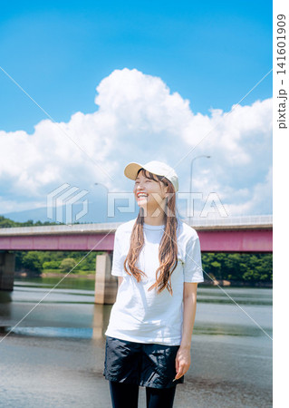 夏空と赤い橋を背景に立つ女性 夏空と赤い橋を背景に立つ女性 141601909
