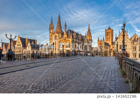 Ghent town in Belgium, Europe. View from St. Michael's Bridge. Historic city square with ancient architecture, cobblestone street, and clear blue sky in an old European town Ghent town in Belgium, Europe. View from St. Michael's Bridge. Historic city square with ancient architecture, cobblestone street, and clear blue sky in an old European town 141602296