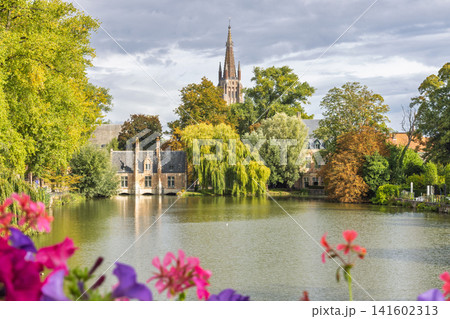 Bruges town in Belgium, Europe. Idyllic European scene with historic architecture, lush trees, and vibrant flowers under a cloudy sky, tranquil water vista Bruges town in Belgium, Europe. Idyllic European scene with historic architecture, lush trees, and vibrant flowers under a cloudy sky, tranquil water vista 141602313