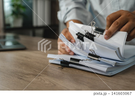 Business office data document graph chart report beside laptop, organizing file bundles for records management, document handling, filing workflow with copy space. Business office data document graph chart report beside laptop, organizing file bundles for records management, document handling, filing workflow with copy space. 141603067