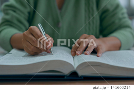 Asian woman reading book at library. Asian woman reading book at library. 141603214