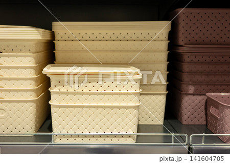 Stacked woven storage baskets in beige and pink on shelf Stacked woven storage baskets in beige and pink on shelf 141604705