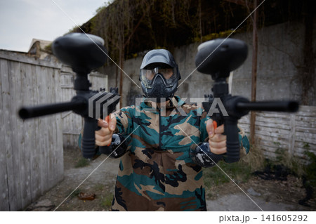A portrait of well-armed and clothed soldier, holding one military gun in each hand A portrait of well-armed and clothed soldier, holding one military gun in each hand 141605292