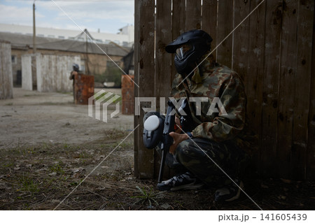 Soldier is taking a defensive position behind the cover during tactical weapon training Soldier is taking a defensive position behind the cover during tactical weapon training 141605439